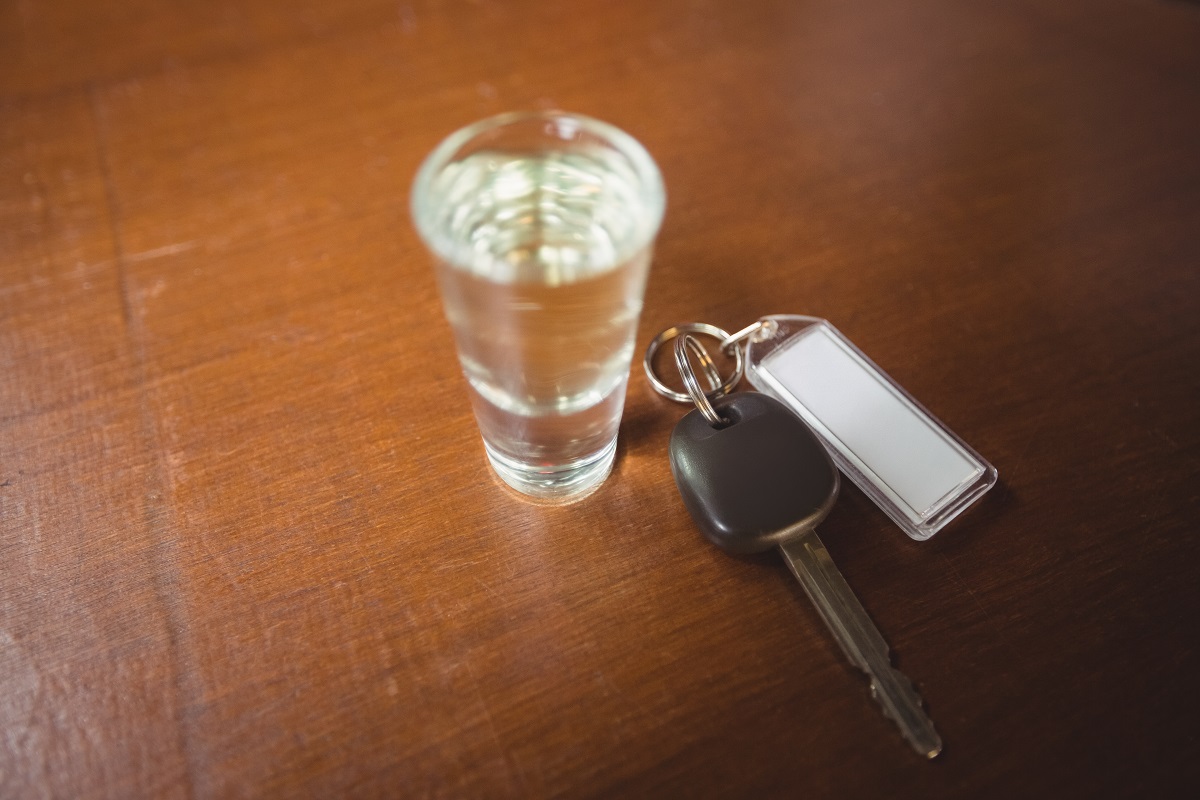 shot glass filled with alcohol and a car key next to it