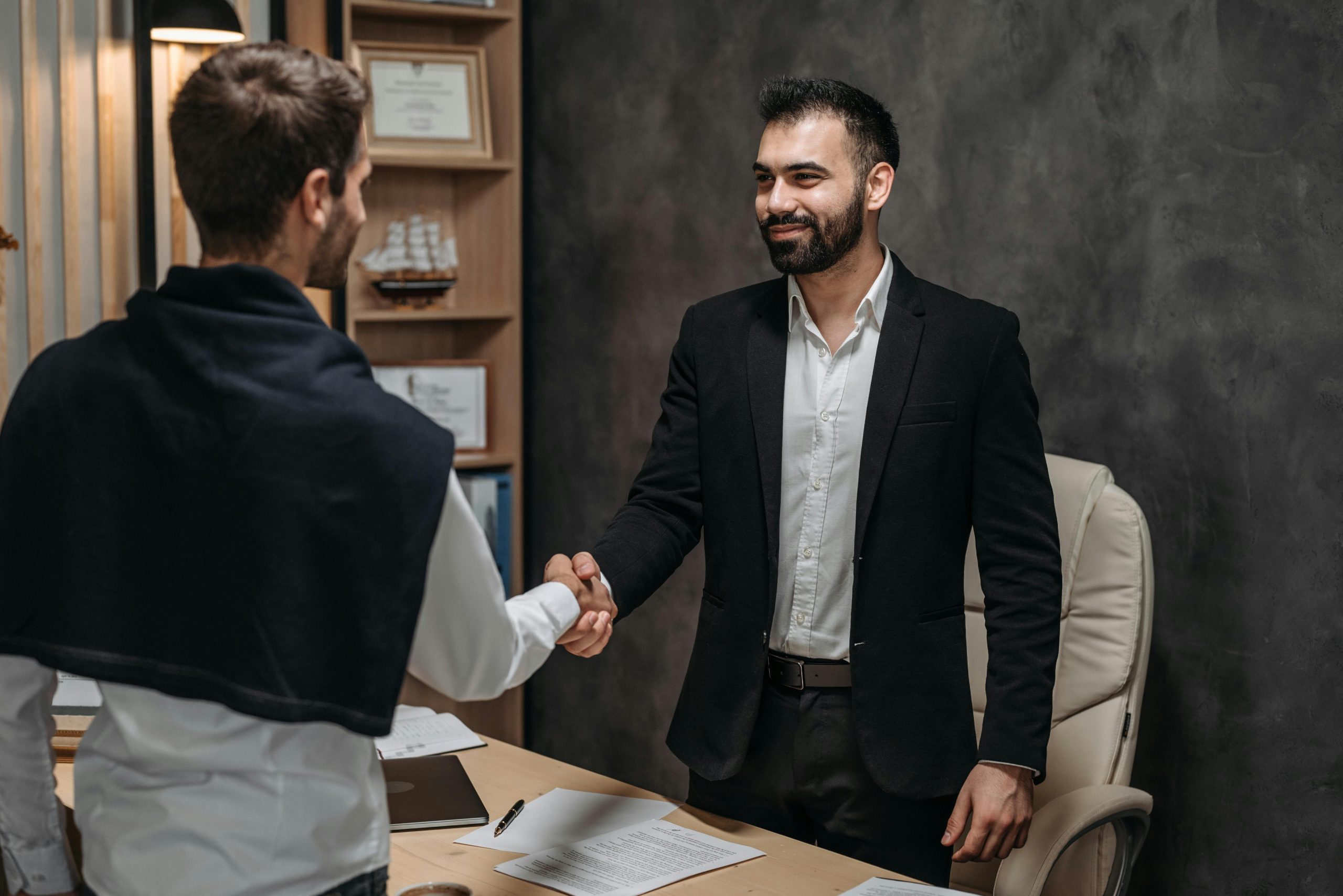 lawyer shaking hands with his client in his office
